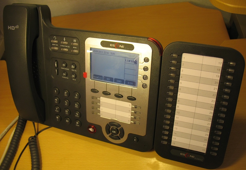 Телефон и модуль расширения на столе