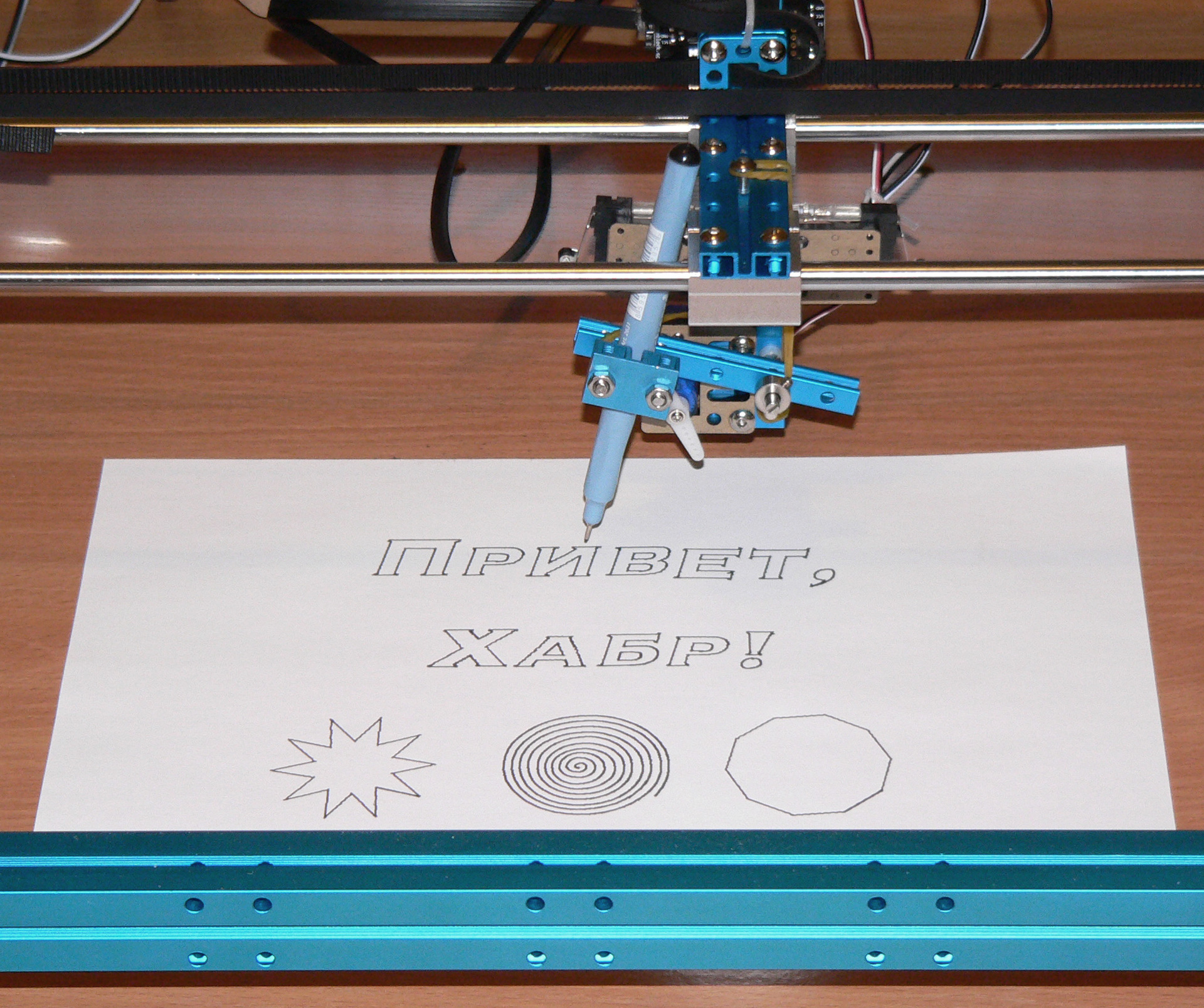 Photo of a plotter with a sheet of paper in which a drawing