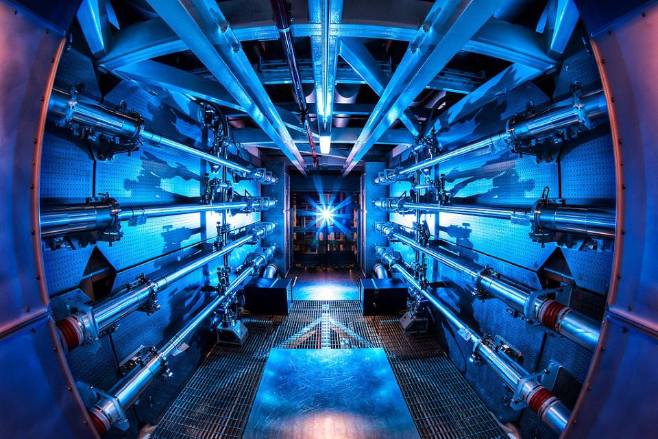 В NIF всенаправленные мощные лазеры нагревают гранулу материала до условий, достаточных для начала ядерного синтеза. В NIF могут создавать температуры, превышающие даже температуру центра Солнца, и в конце 2022 года впервые была пройдена точка безубыточности с точки зрения энергии лазера, падающей на водородную мишень, по отношению к энергии, высвобождаемой в результате запущенных термоядерных реакций.