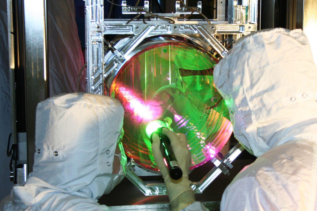 Зеркала с покрытием и охлаждением в передовом эксперименте LIGO, показанные здесь, реагируют на каждый фотон, который попадает на них. Обнаружение гравитационной волны зависит от изменения положения зеркала и последующего изменения длины пути фотона, которое оно испытывает при прохождении через него гравитационной волны. Лаборатория Caltech/MIT/LIGO