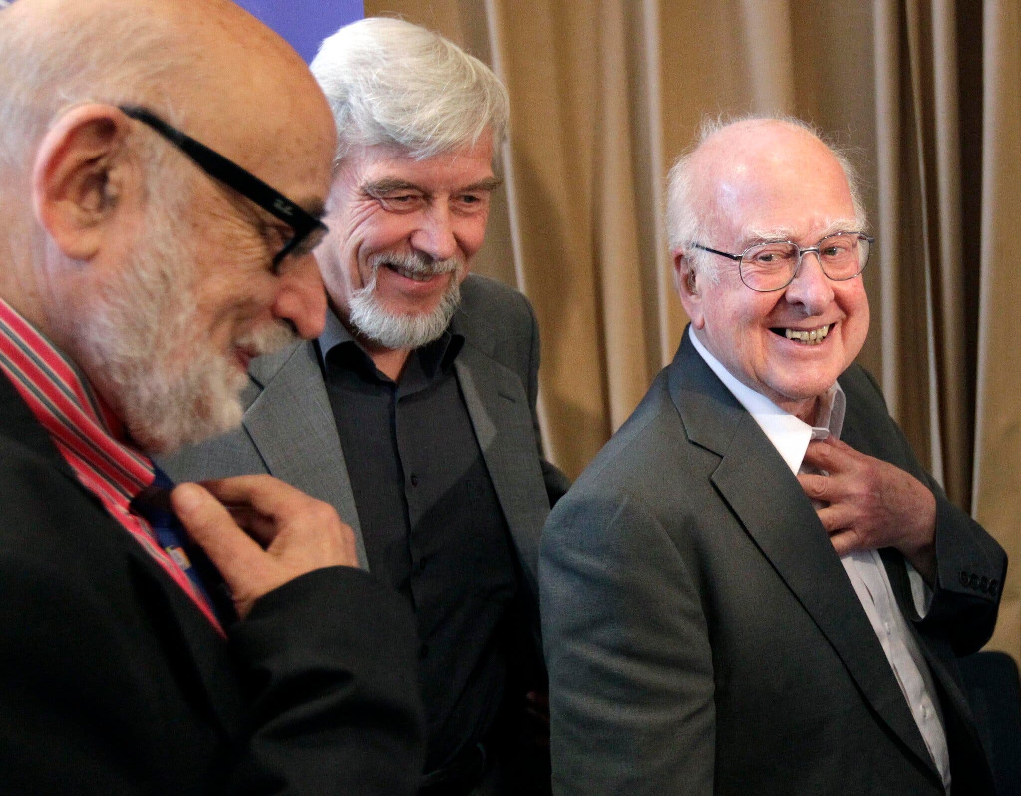  Доктор Хиггс (справа) встретился с бельгийским физиком Франсуа Энглером (слева) в 2012 году в Европейской организации ядерных исследований (ЦЕРН) в Мейрине, Швейцария, недалеко от Женевы. Вместе с ними был Рольф Хойер, генеральный директор ЦЕРН. В следующем году доктор Хиггс и доктор Энглерт разделили Нобелевскую премию по физике.