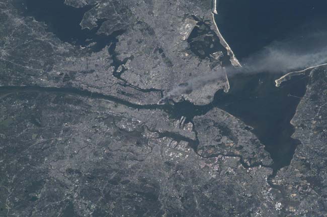Фотография, сделанная с борта МКС в момент столкновения самолета в первую башню. Credit: NASA.