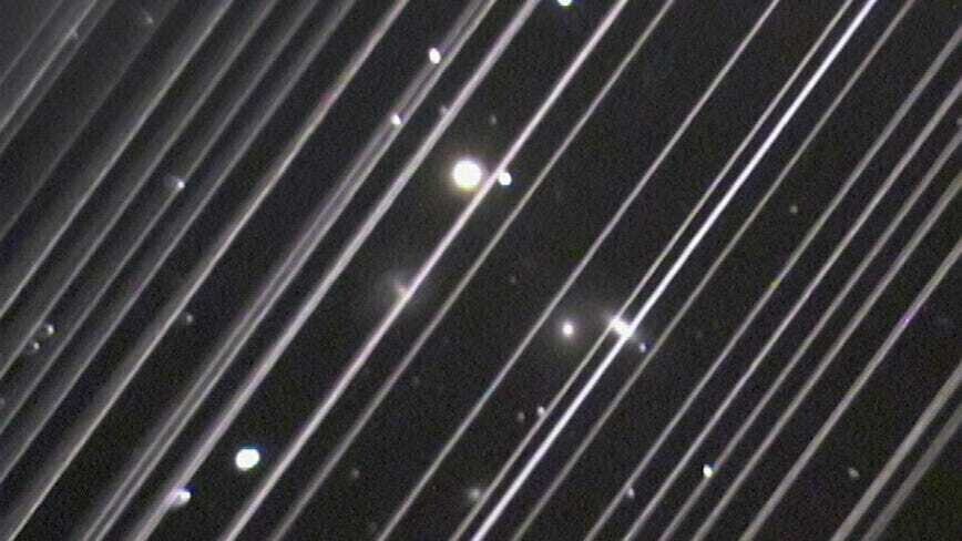 Изображение группы галактик, перекрытые диагональными линиями — следами от спутников Starlink. Фото обсерватории Лоуэлла