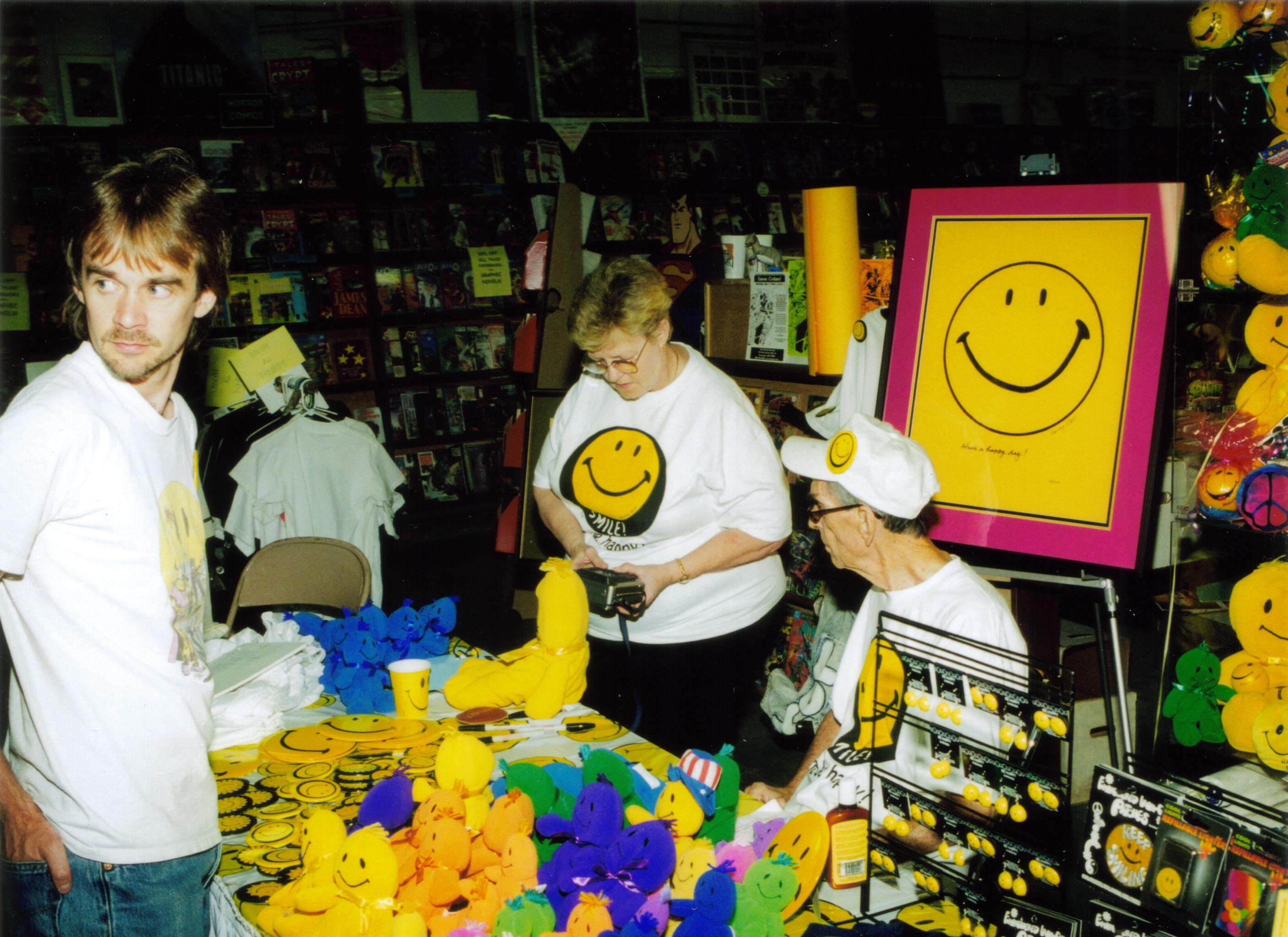Рис. 3 На одном из благотворительных мероприятий в 1998г. Харви раздает изображения со смайликом бесплатно