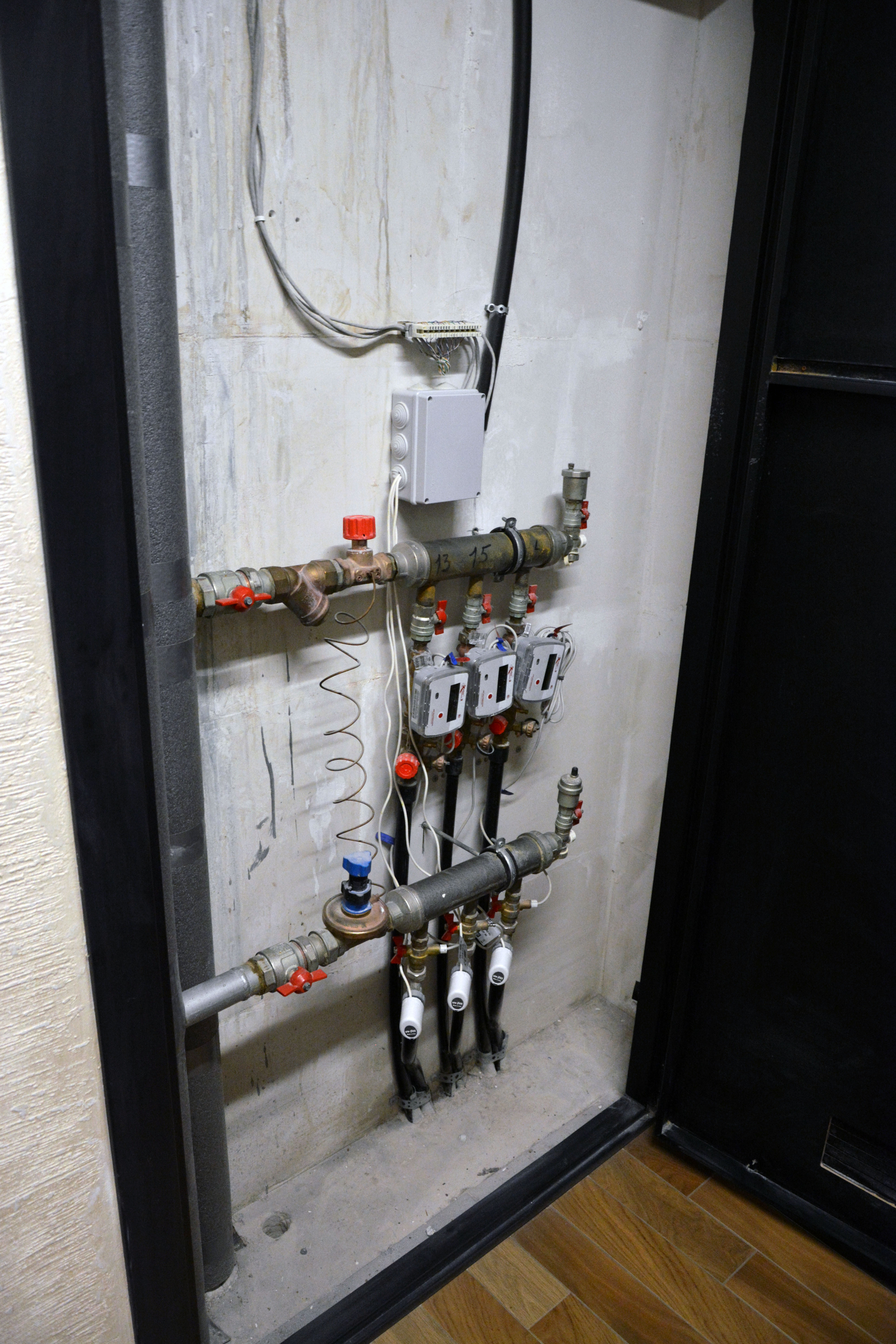 Электроприводы вентилей, регулирующие поступление теплоносителя в систему отопления квартир. Чуть выше установлены счетчики тепла. В сером герметичном корпусе – реле WB-MR6C