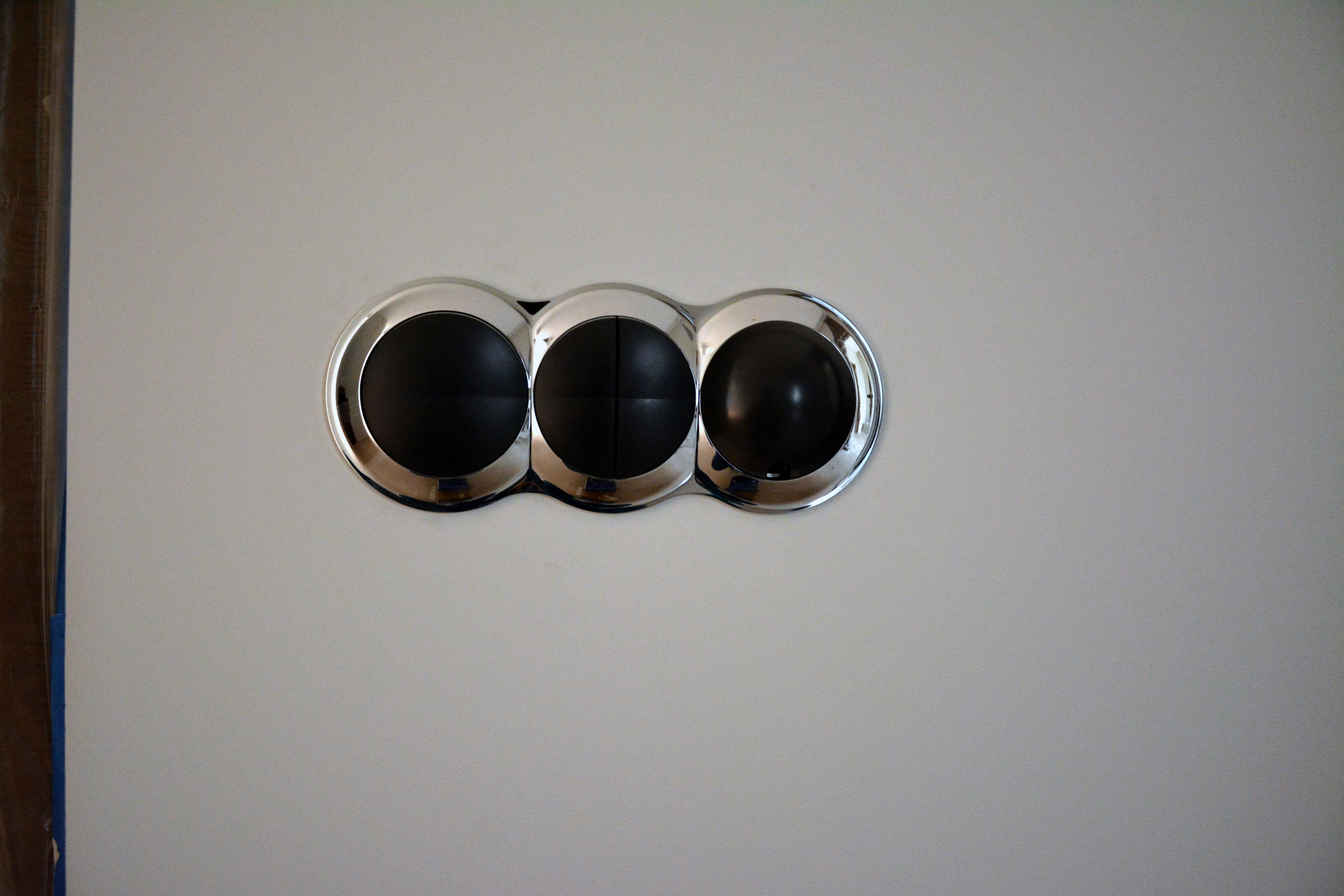 Слева — два клавишных выключателя, справа — датчик температуры в подрозетнике. Едва заметно отверстие в нижней части черного круга, в котором располагается датчик