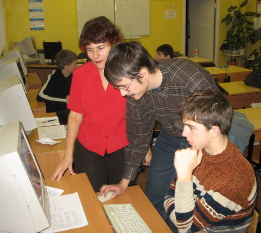 Студент-третьекурсник разбирает с учеником, почему тесты падают. Слева — руководитель и идейный вдохновитель кружка, учительница информатики.