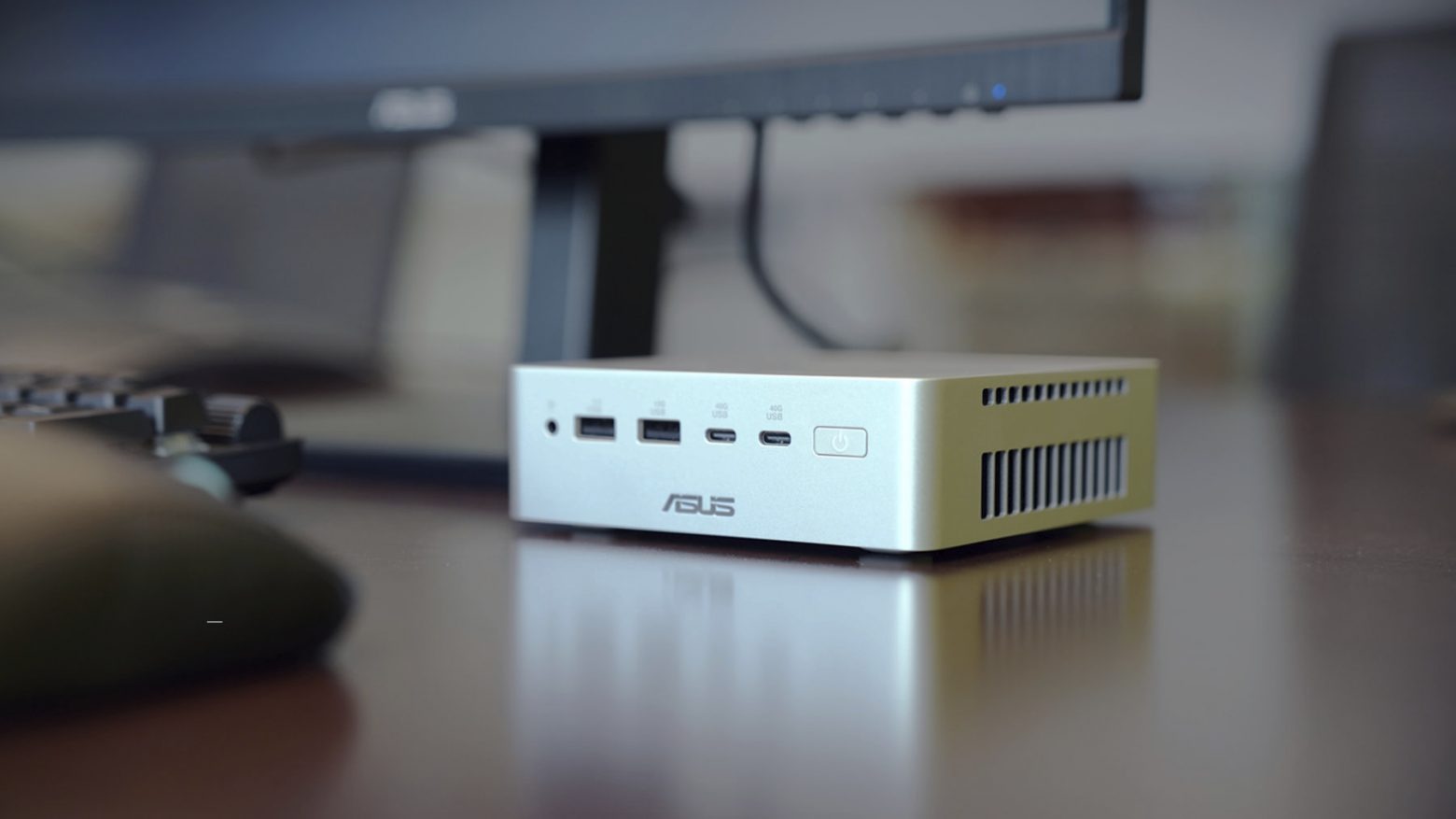 Мини-ПК ASUS Ascent QN10 на базе процессора Snapdragon X2 Elite на рабочем столе под монитором.