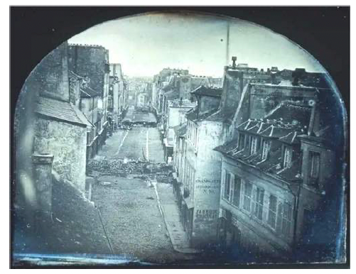 Первая в истории фотография, напечатанная в газете (1848 год). На ней показаны последствия бунтов в Париже. В центре — разрушенная  баррикада поперек улицы  