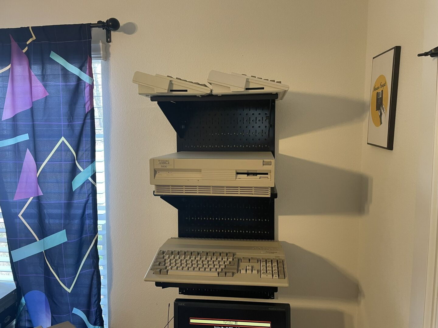 Рядом с окном, закрытым ретро-занавесками, Грин установил полку с Amiga 500, Amiga 3000 и двумя компьютерами Amiga 600.