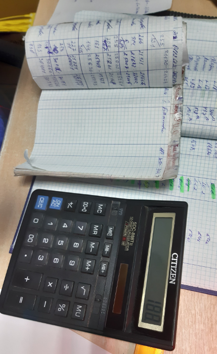 Настольный калькулятор и журналы на столе диспетчера