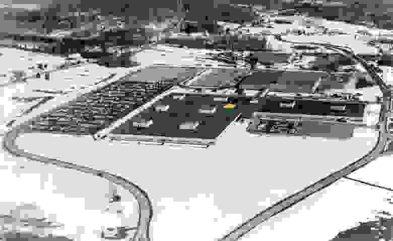 A black-and-white photo shows an overhead view of an IBM semiconductor facility in the 1960s.