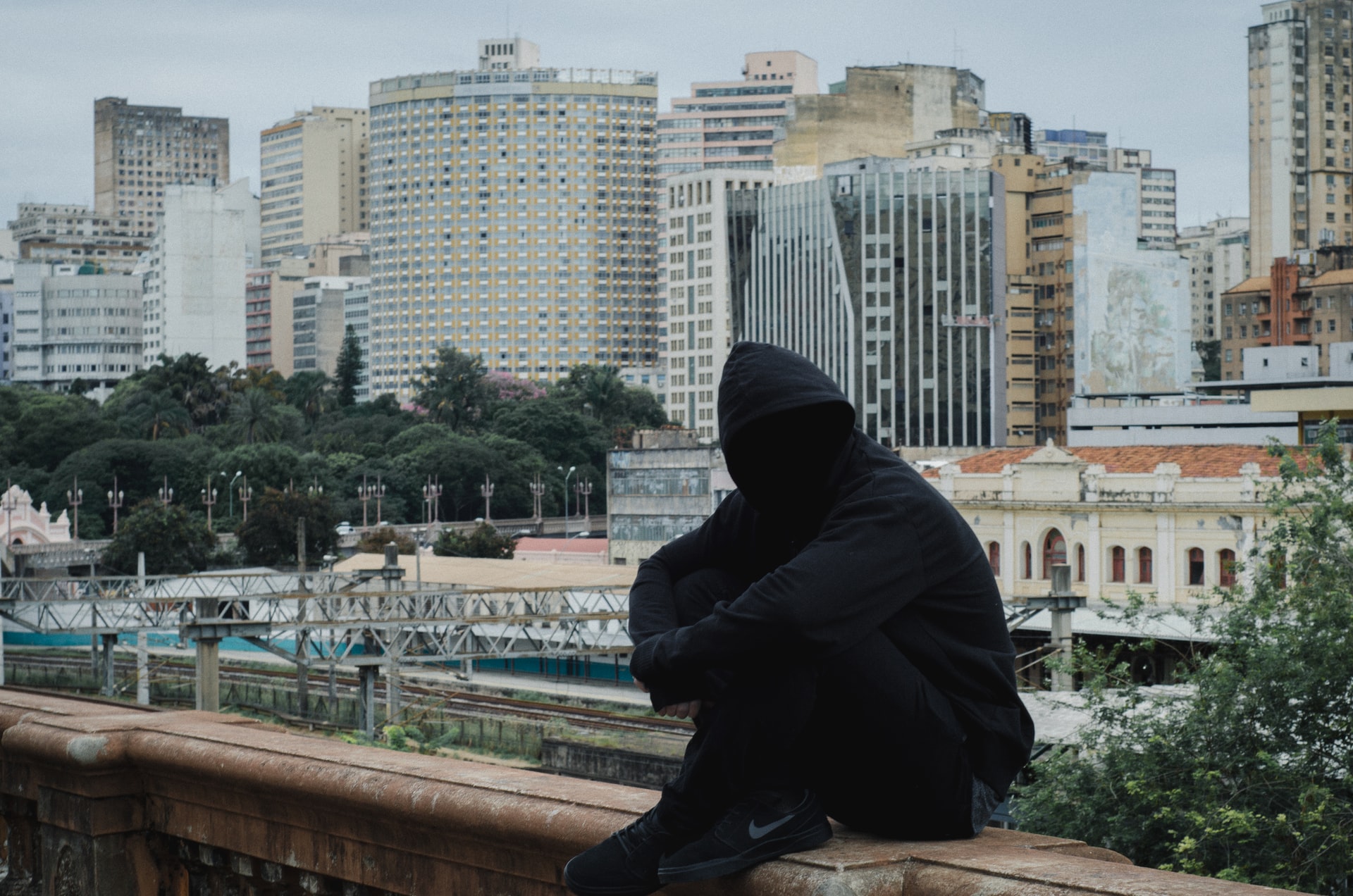 Грустный чувак в капюшоне на фоне сурового мегаполиса – куда ж нам без него, если мы пишем об анонимности – вольная интерпретация стоковой фотографии. Фото: Daniel Monteiro // Unsplash (CC BY-SA 4.0)